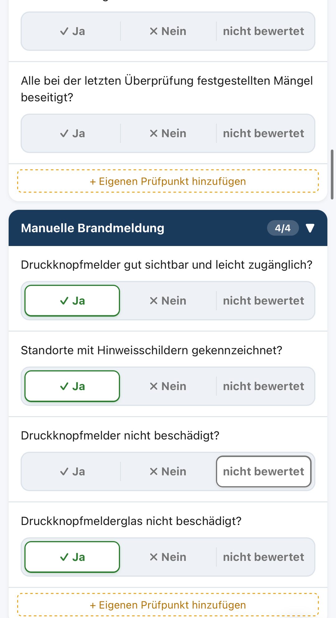 VigilOS Brandschutz Begehung auf dem iPhone: Kategorie Manuelle Brandmeldung mit vier Prüfpunkten, drei mit „Ja“ bewertet, einer „nicht bewertet“, darüber zwei Prüfpunkte der vorigen Kategorie